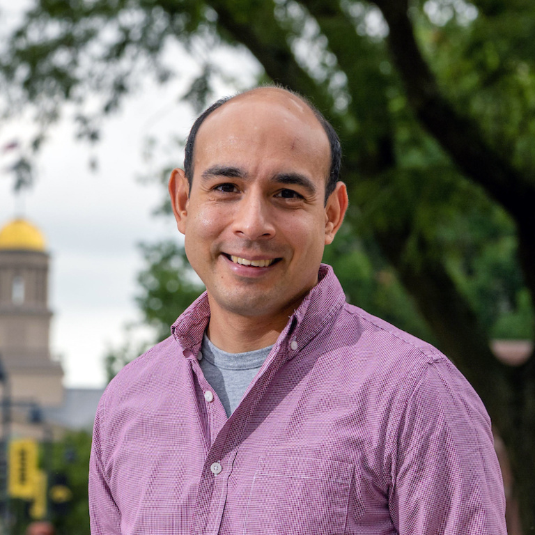 Rene Rocha stands in front of old capital smiling