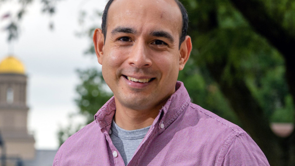 Rene Rocha stands in front of old capital smiling